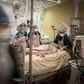 Doctors and nurses tending to a COVID-19 patient in the intensive care unit at the Lariboisiere hospital in Paris
