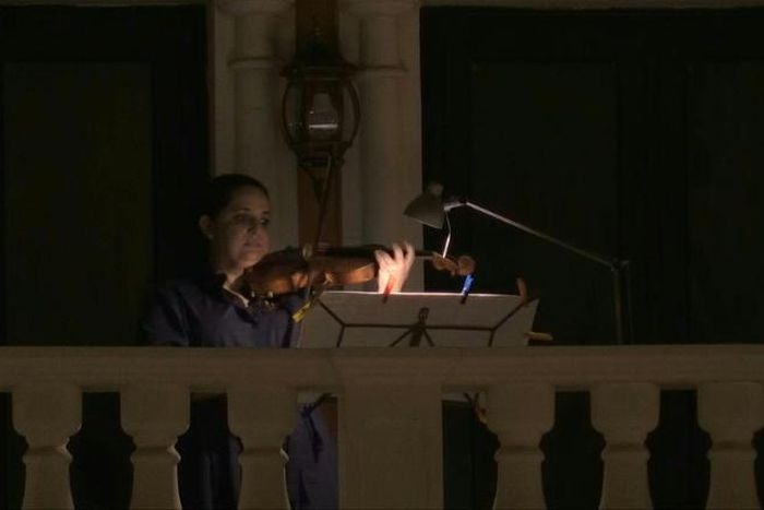 Members of Qatar's philharmonic orchestra perform from their balconies one last time before Ramadan in Qatar's Qanat Quartier, a part of Doha's man-made Pearl island