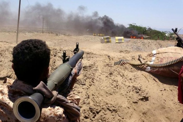 A southern separatist fighter watches as a military vehicle belonging to Yemen's Saudi-backed government forces burns during clashes in Abyan province on May 11