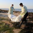 Tunisian workers remove a migrant's body recovered after a previous shipwreck in July 2019
