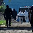 Forensic experts take away a corpse from the women's prison in Tamara, Honduras following the murder of six inmates