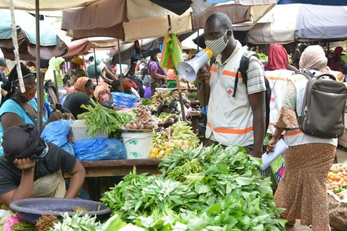 The defiant mood is deepened by the need to make a living. At a Conakry market, the Red Cross spreads the word on fighting the virus