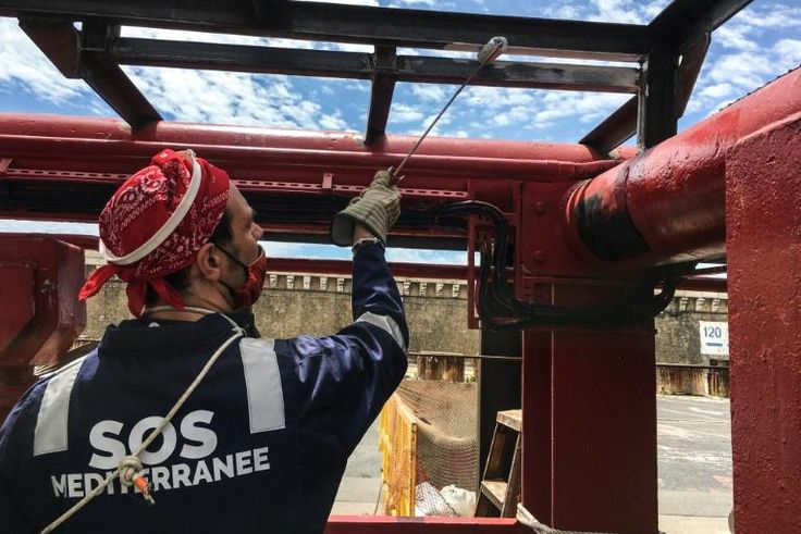 A crew member of French NGO SOS Mediterranee rescue boat Ocean Viking paints parts of the boat moored in the port of Marseille, on the eve of a scheduled departure for a migrants search and rescue mission off the coast of Libya