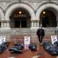 Participants in a "People's Motorcade" stop at the Trump International Hotel to deliver fake body bags during a protest against the administration's response to the COVID-19 pandemic in Washington, DC