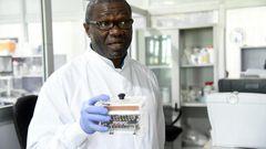 Molecular biologist Christian Happi, head of the ACEGID genomics lab, holds a thermal cycler, which amplifies genetic segments of the virus