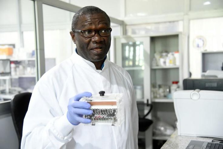 Molecular biologist Christian Happi, head of the ACEGID genomics lab, holds a thermal cycler, which amplifies genetic segments of the virus