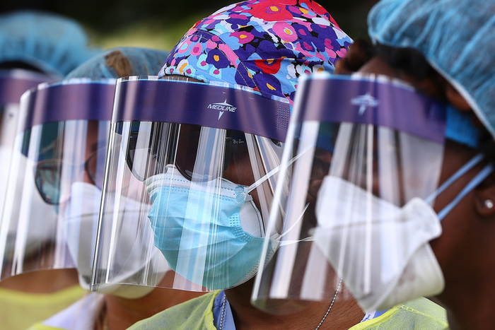 FILE - In this May 4, 2020, file photo, volunteers line up to begin taking hundreds of free COVID-19 tests at a pop-up site at the House of Hope in Decatur, Ga. Many African Americans watching protests calling for easing restrictions meant to slow the ...