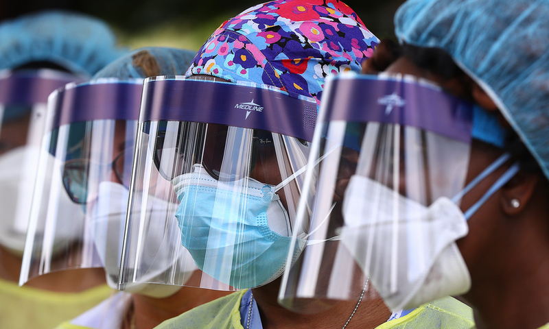 FILE - In this May 4, 2020, file photo, volunteers line up to begin taking hundreds of free COVID-19 tests at a pop-up site at the House of Hope in Decatur, Ga. Many African Americans watching protests calling for easing restrictions meant to slow the ...
