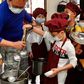 Students wearing face masks as a preventive measure to curb the spread of the COVID-19 coronavirus collect their lunch at an elementary school in Taipei in April 2020