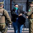 Chilean security forces check a woman's documents as they enforce a total quarantine to prevent the spread of the coronavirus in Santiago, on June 10, 2020