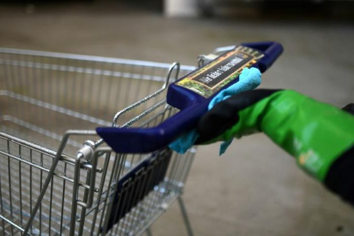 Katharina Obladen and Tanja Nickel have seen demand for their virus-killer products skyrocket -- here a student cleans a shopping trolley for disinfection at their workshop in Cologne