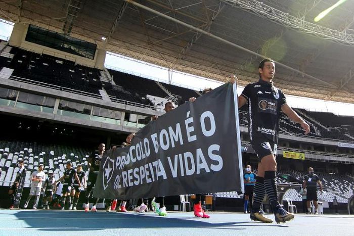 Botafogo club footballer Keisuke Honda and teammates display a banner reading "A good protocol is one which respects lives" as a protest against the resumption of the Carioca Championship, before their closed-door match against Cabofriense in Rio de Ja...