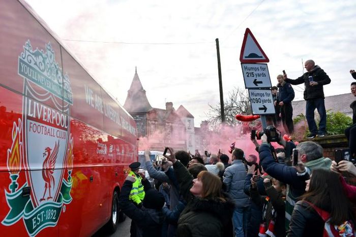 Fans cheer as the Liverpool team bus arrives at Anfield