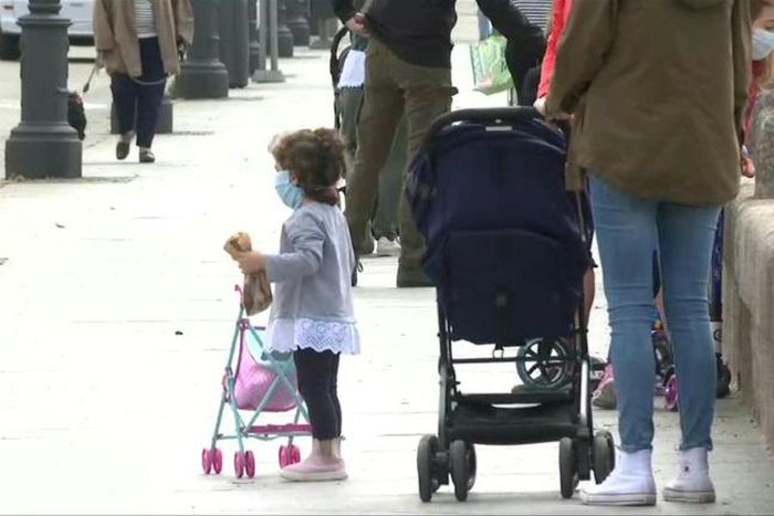 Children in Madrid enjoy the sunshine with their parents, as they are allowed outside on Sunday for the first time in six weeks