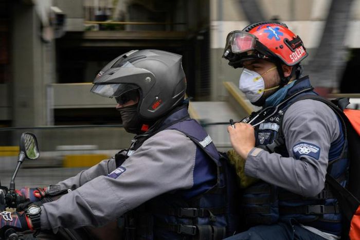 Members of the NGO paramedic group "Angels of the Roads" ride on a motorbike in Caracas, Venezuela