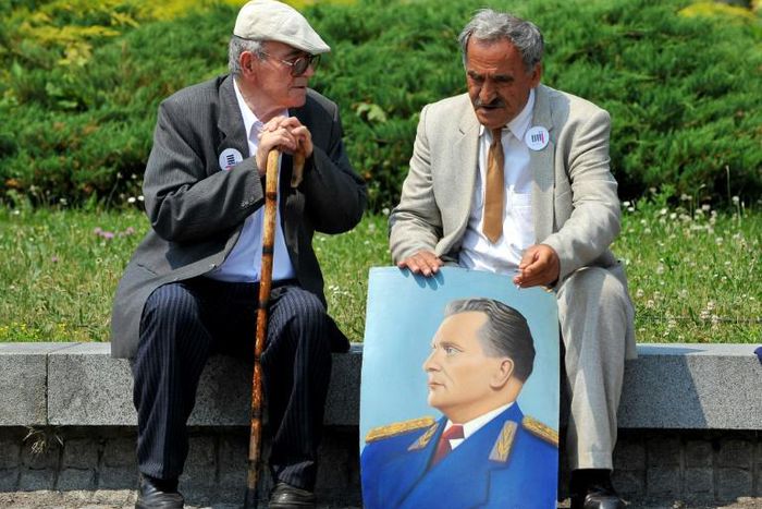 Two admirers reminisce about the late Yugoslav communist president Josip Broz Tito, commemorated in the portrait