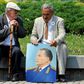 Two admirers reminisce about the late Yugoslav communist president Josip Broz Tito, commemorated in the portrait