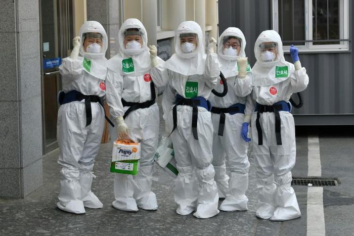 South Korean nurses wearing protective gear pose as they start their shift to care for patients infected with the COVID-19 coronavirus at a hospital in Daegu -- the country reported zero new infections for the first time