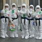 South Korean nurses wearing protective gear pose as they start their shift to care for patients infected with the COVID-19 coronavirus at a hospital in Daegu -- the country reported zero new infections for the first time