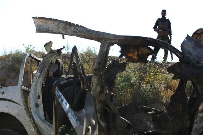 An Iraqi fighter with the Hashed al-Shaabi paramilitary force inspects the site of an attack by Islamic State group in early May 2020 in Mukaishefah, about 180 kilometers (110 miles) north of Baghdad