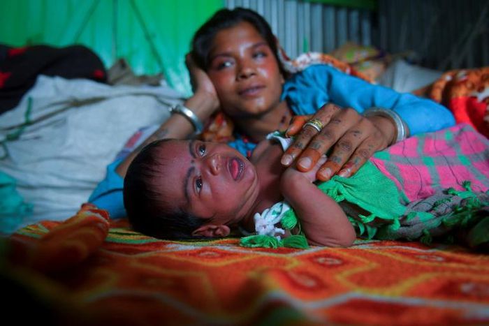 Manju Bauri rests with her newborn baby boy 'Lockdown' in their temporary home in northeast India
