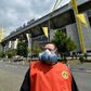 A Borussia Dortmund worker wears a mask outside the Signal Iduna Park stadium before the team face Schalke 04 as the Bundesliga resumes