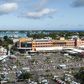 An aerial shot taken in April 2020 shows people waiting while adhering to social distancing in a parking lot before entering a supermarket in Grand Baie, Mauritius; the country has declared wary victory over the coronavirus