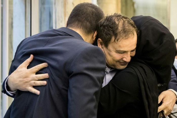 Iranian doctor Majid Taheri, who had been detained in the United States for 16 months, hugs his children upon his arrival at Tehran's Imam Khomeini International Airport on Monday