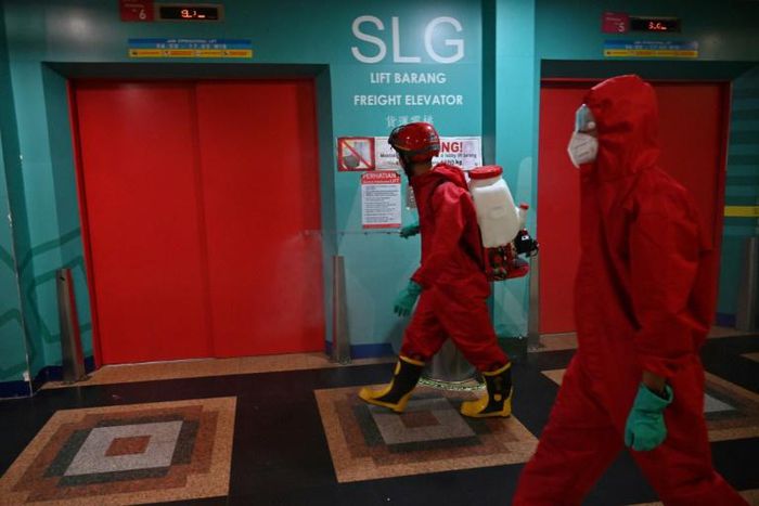 Indonesian fire fighters spray disinfectant at a business center on the last day of the lockdown amid the COVID-19 coronavirus pandemic in Jakarta