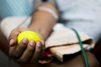 selective focus of blood collection during blood donation and ball in palm for squeezing