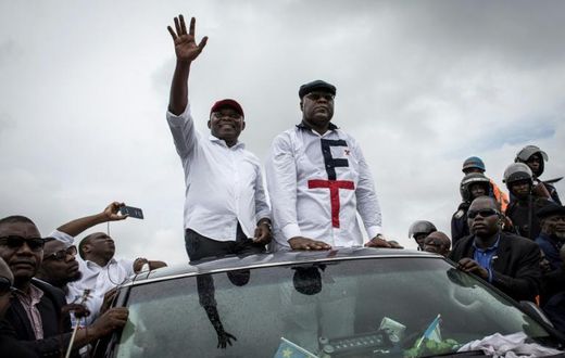 In happier times: Tshisekedi, right, and Vital Kamerhe, wave to supporters at an election campaign rally in Kinshasa in November 2018