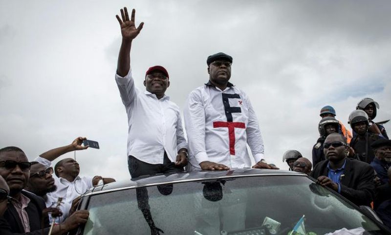 In happier times: Tshisekedi, right, and Vital Kamerhe, wave to supporters at an election campaign rally in Kinshasa in November 2018