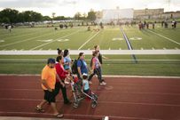 Activist Roxanne Martinez, wearing backpack, walks on a track in Fort Worth.