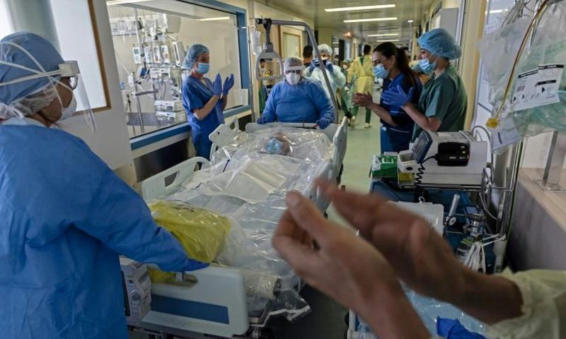 Intensive care workers at Nicosia General Hospital cheer as a coronavirus patient is transferred back to the recovery department on Wednesday