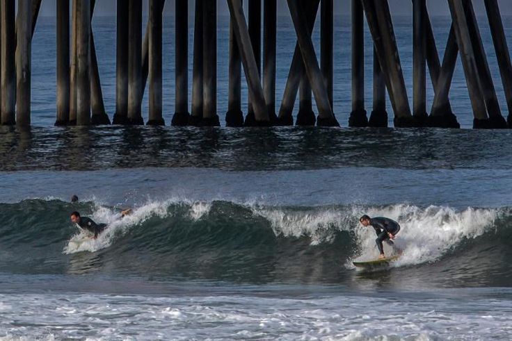 Surfers catch a wave in Huntington Beach, California on May 2