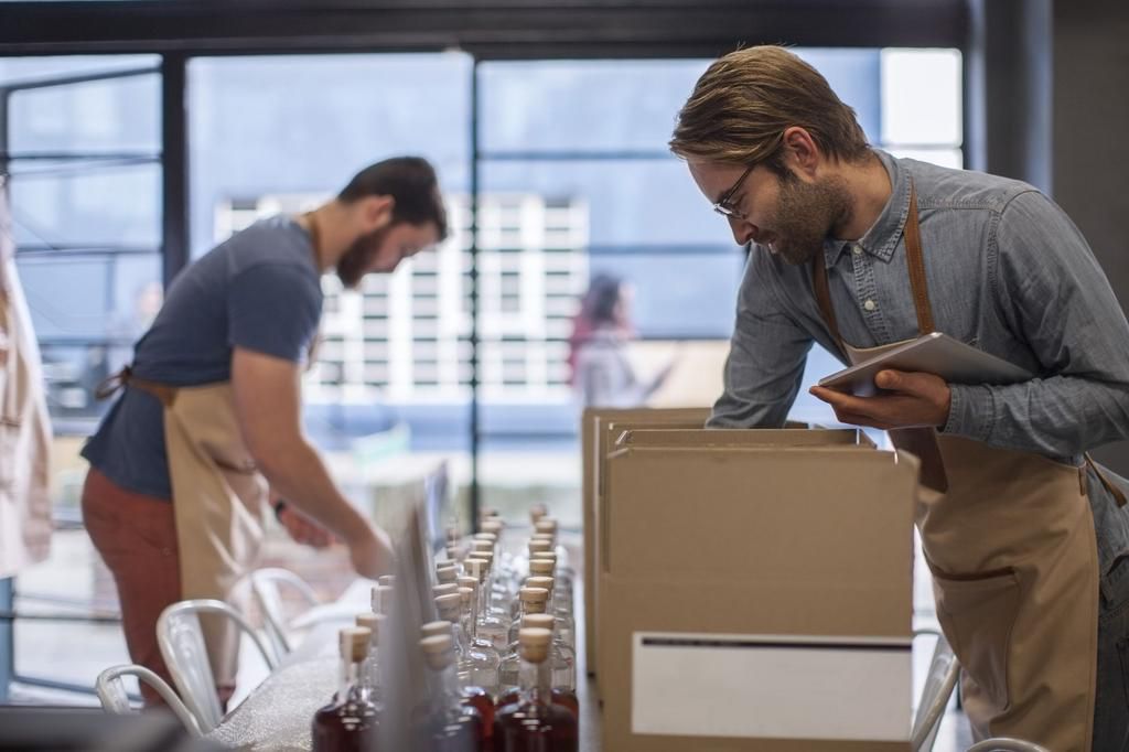 Two colleagues shipping liquor in a distillery