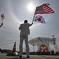 A man and a woman wave flags during a ceremony at the US Camp Humphreys in Pyeongtaek in June, 2019