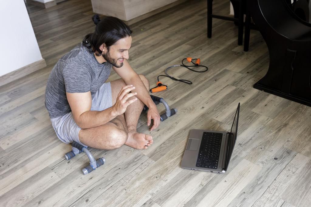 young man searches his training routine on youtube before starting to exercise at home