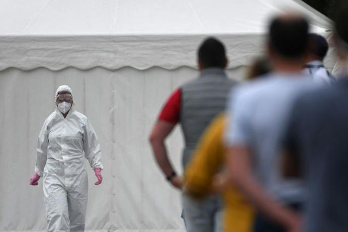 Workers queue for a coronavirus test at the Westfleisch meat processing company in Hamm as all require a test after a spike in cases at their slaughterhouse