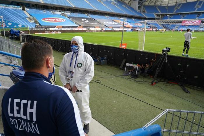 A man in a protective suit stands pitchside in Poznan before the restart of the Polish season last weekend following the coronavirus shutdown