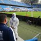 A man in a protective suit stands pitchside in Poznan before the restart of the Polish season last weekend following the coronavirus shutdown