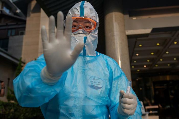 A medical worker prepares to take swab samples from a journalist to test for the COVID-19 coronavirus in Beijing