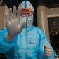 A medical worker prepares to take swab samples from a journalist to test for the COVID-19 coronavirus in Beijing