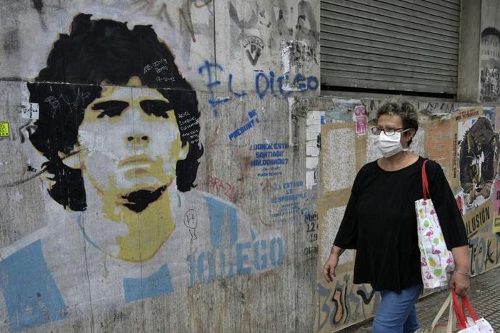 'Hand of God' needed: A woman walks past an image of Diego Maradona during the lockdown in Argentina