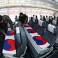 Flag-wrapped coffins containing the remains of nearly 150 South Koreans killed in the Korean War were flown back to Seoul