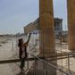 A worker (pictured May 18, 2020) wearing a protective mask cleans a divider made of plexiglass at the entrance of the Acropolis in Athens amid the pandemic of the novel coronavirus