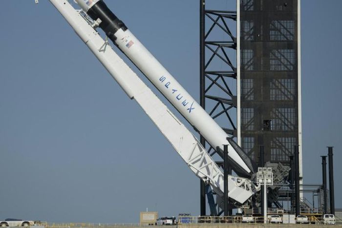 SpaceX's Falcon 9 rocket is raised into a vertical position on the launch pad ahead of the crewed mission to the International Space Station