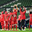 Bayern Munich players celebrate in front of near-empty stands after securing an eighth straight Bundesliga title