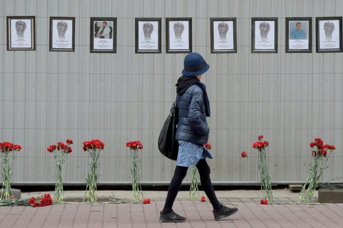 A woman walks past a makeshift memorial for Russian medical workers who have died from the COVID-19 disease, set up outside the local health department in Saint Petersburg. More than 70 have died so far.