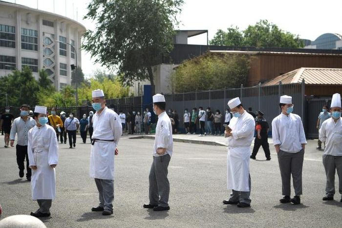 Restaurant workers line up in Beijing as part of a mass virus testing effort